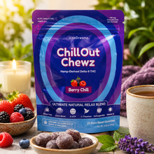 Load image into Gallery viewer, A stand-up pouch of VitaDreamz Chill Out Chewz Berry Chill gummies is displayed in a styled setting with fresh berries, a cup of tea, and lavender flowers. The packaging is predominantly purple and blue with white text.
