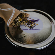 Close-up of a bowl with a spoon containing a green leafy substance, possibly a soup or stew.