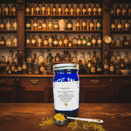 Blue jar of ginger root powder with a spoonful of powder on a patterned background