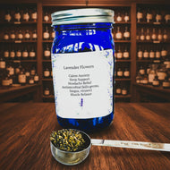 Blue jar of lavender flowers with a label on a white surface with a patterned background