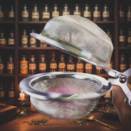 Metal tea infuser held over a magazine with a blurred background