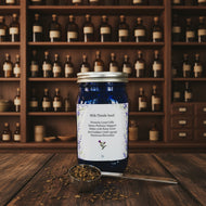 Blue jar of milk thistle seed with a spoonful of seeds on a patterned background