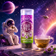 Load image into Gallery viewer, A clear cylindrical canister of loose leaf CBD tea labeled 'planet passion green tea' stands on a space-themed set with an astronaut drinking tea, a glass mug of tea, planets, stars, and a small flower.
