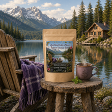 Load image into Gallery viewer, Package of 'Quiet Mind Calm &amp; Stress Support Botanical Blend' with a steaming mug on a wooden stool by a lake with mountains in the background.