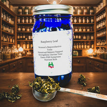 Load image into Gallery viewer, Blue jar labeled 'Raspberry Leaf' with a spoonful of dried herbs on a patterned background